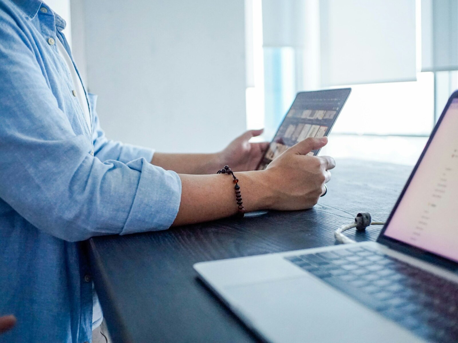 Werken aan een laptop met documenten op een licht bureau